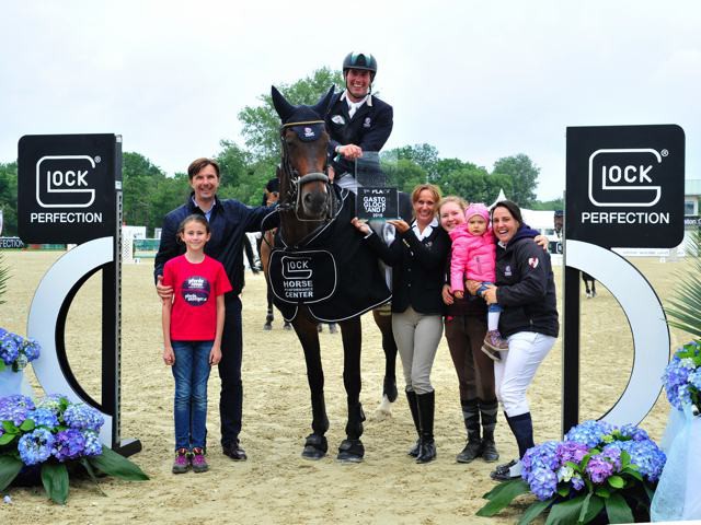 Beaming winner of Gaston Glock's Grand Prix Magna Racino: Gert Jan Bruggink (NED) on MCB Ulke being congratulated by Marcus Wallishauser (Magna Racino), award ceremony child Laura, Ulrike Payrer (GHPC), Groom Anna and Gert Jan’s partner Pia-Luise Aufrecht with their daughter. © GHPC / studiohorst