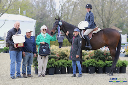 Keirstin Johnsen and Hennepin, along with owner Shelly Ferrall and groom Fidel Ventura, are awarded with the champion ribbon, as well as the Debby Malloy Winkler Memorial Trophy, donated by the Malloy Family and presented by Vivien and Mark Malloy. © Jump Media