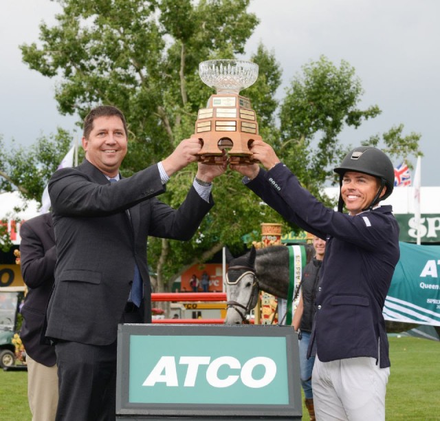 Kent Farrington raises the Queen Elizabeth II Cup with Wayne Stensby, Managing Director, ATCO’s Electricity Global Business Unit. © Spruce Meadows Media Services