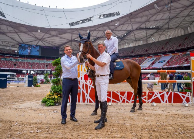 Felix Magath im Sattel von „Let’s go“. Als Grooms assistieren Ludger Beerbaum (rechts) und Michael Mronz. © Longines Beijing Equestrian Masters / Arnd Bronkhorst