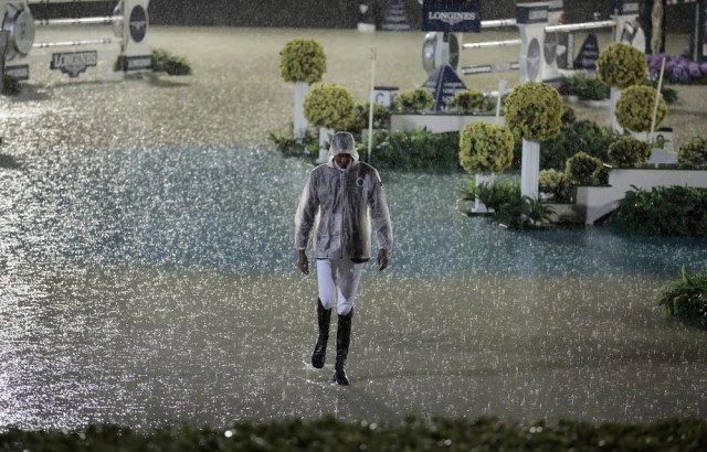Sheikh Ali al Thani from Qatar walks onto the field of play where the water jump has broken it constraints and exands during a heavy rain storm in Barcelona. © FEI / Jim Hollander