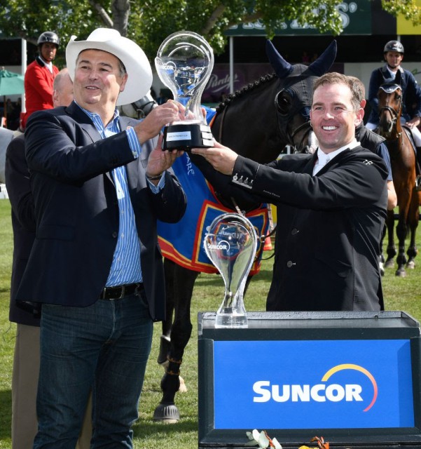 Cian O’Connor raises the winning trophy with Steve Reynish, Executive Vice President, Strategy & Corporate Development, Suncor Energy. © Spruce Meadows Media Services