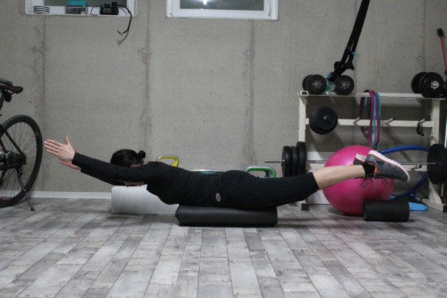 „Rückenschiffchen“ zur Kräftigung der Rücken- und Gesäßmuskulatur auf einer zusammengerollten Gymnastikmatte - © fit 4 riding®